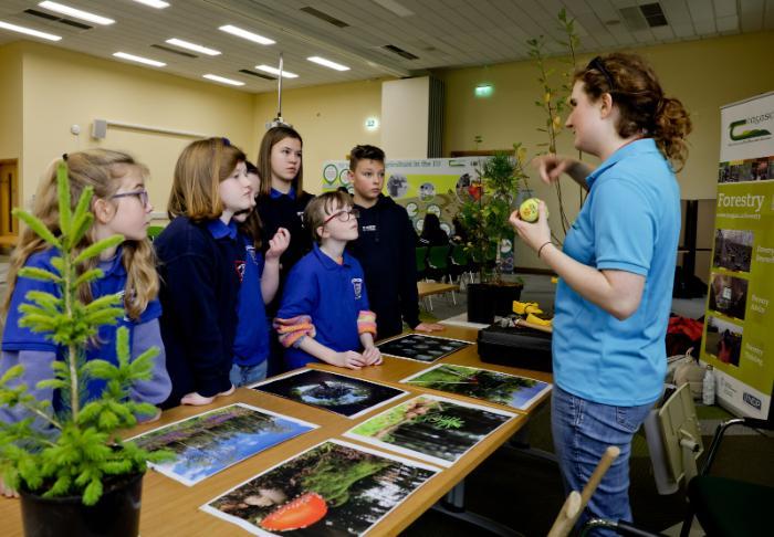 Researcher talking with group of secondary school students during Science Week 2023
