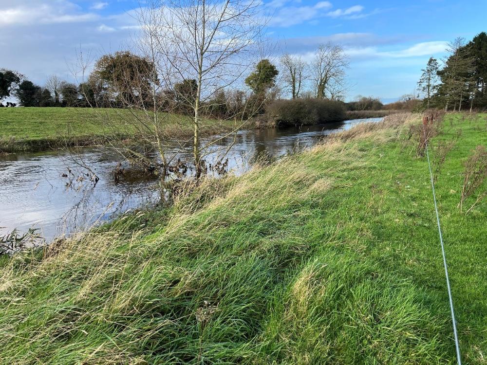 Fenced river along the farm