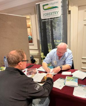 Forestry advisor speaking with landowner at Lets Talk Trees event