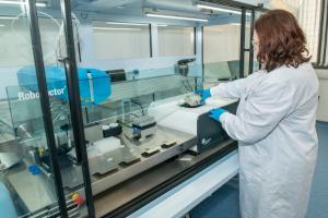 Teagasc scientist loading a sample plate on the micro-fermenter in the Bioprocess Innovation Suite