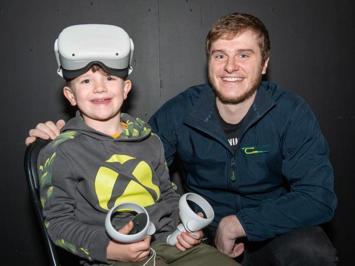 Teagasc scientist with child attending event wearing Virtual reality goggles