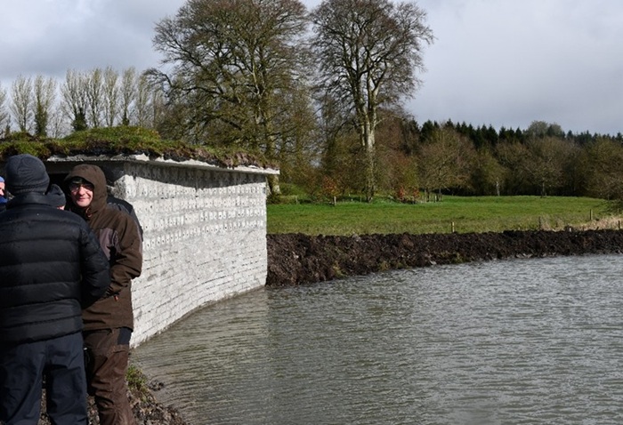 A sand martin house along side a pond