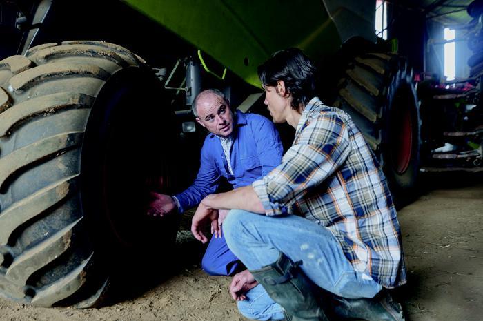 Two en looking at a tractor.