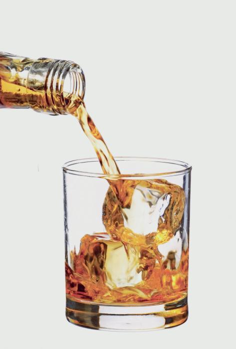 An image of whiskey being poured into a glass