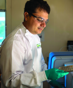 Researcher holding tray of vials.