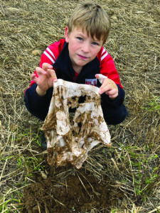 Kid holding dirty clothes.