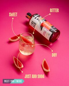 A bottle laying flat, label reads; Rhubarb & Grapefruit flavour