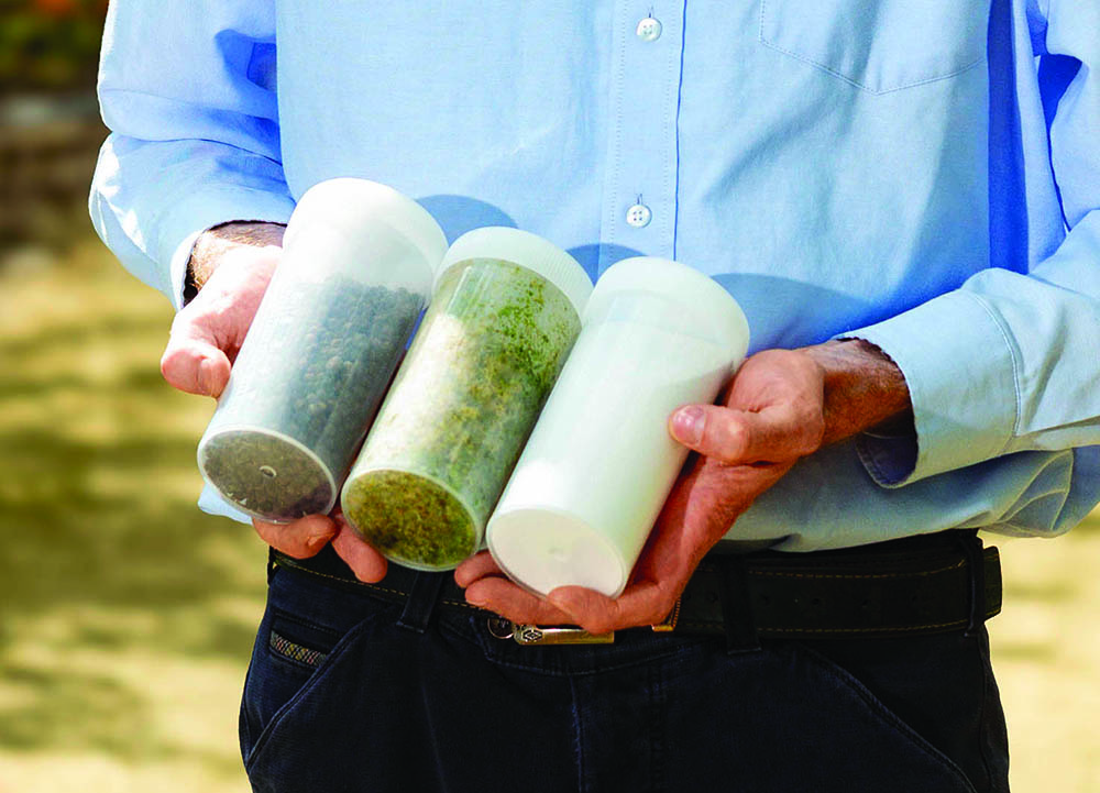 A man hods three containers of different bio-based products