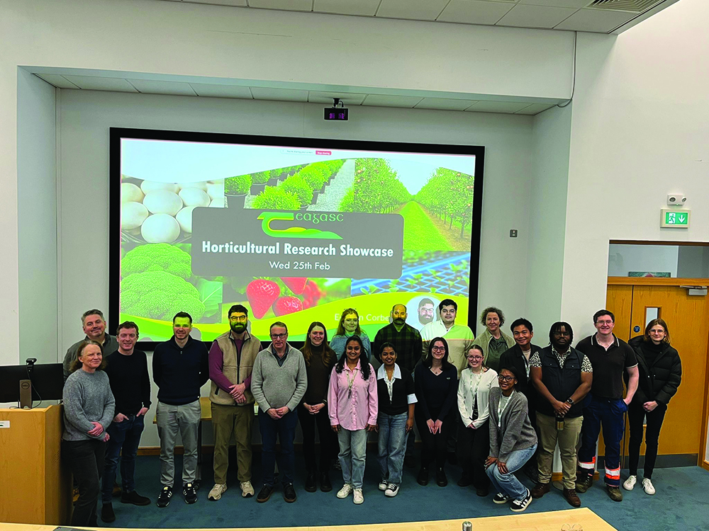 A group of scientists stand at the front of a lecture hall
