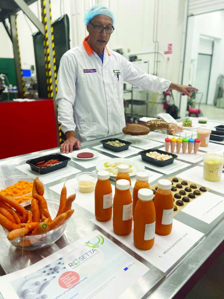 A man displays several value-added products developed from carrots