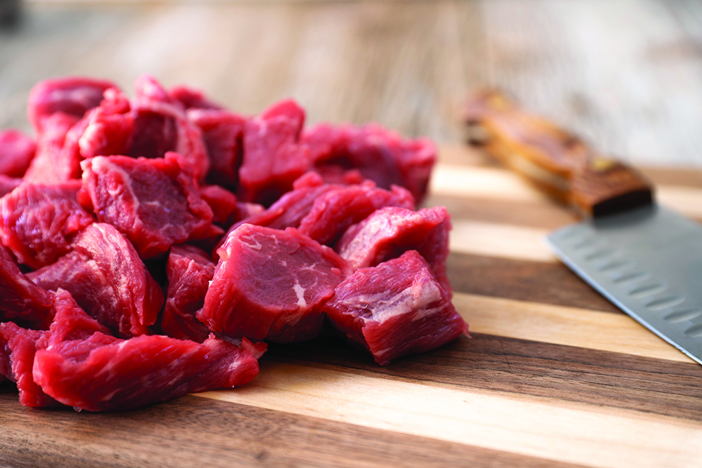 Beef cubes on a cutting board
