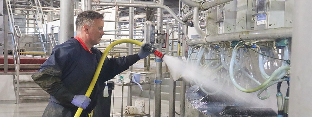 Cover image representing A farmer cleaning a milking parlour