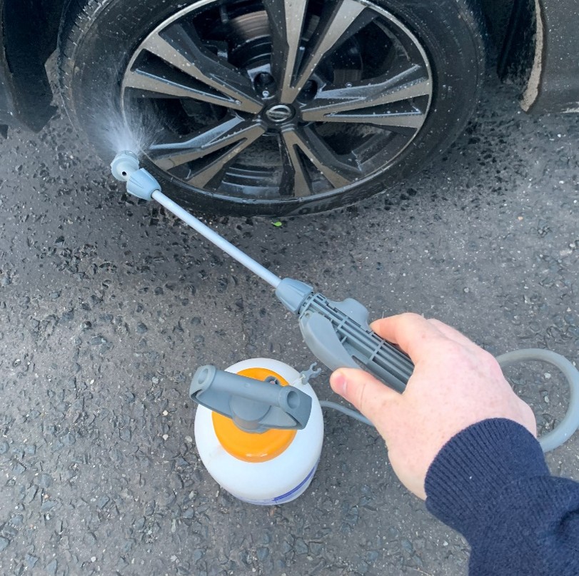 Photo of the wheels of a vehicle being disinfected before entering
